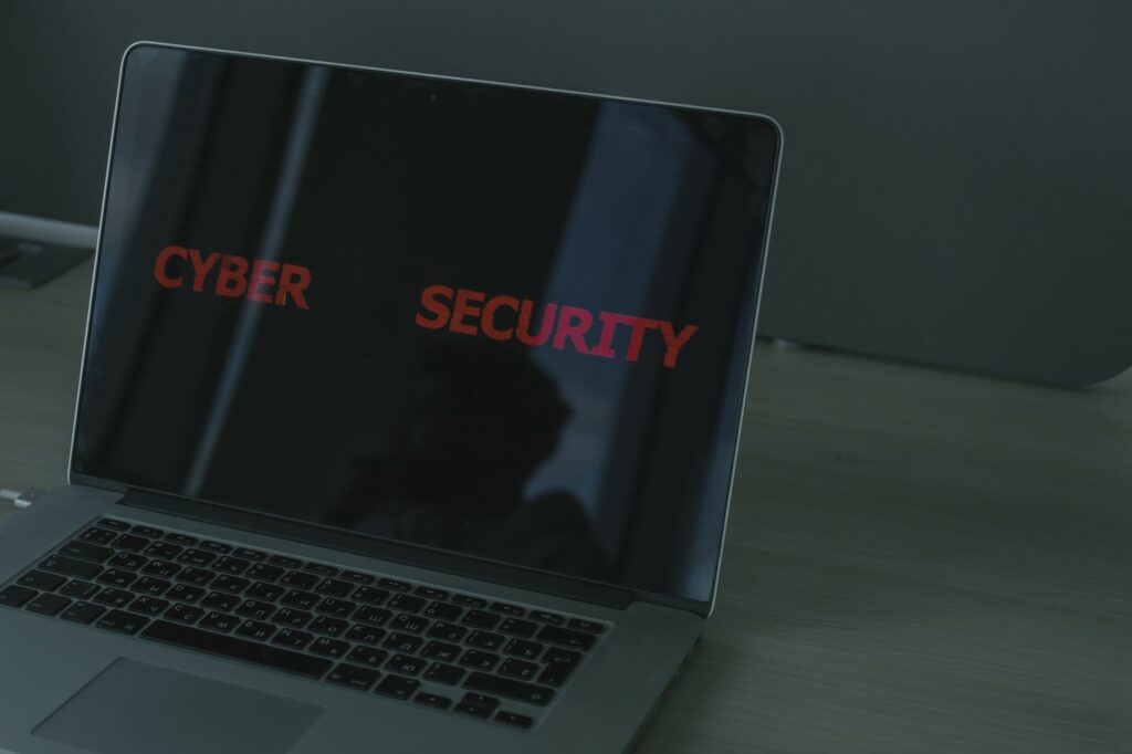 ノートパソコンの画面に「CYBER SECURITY」と赤い文字で表示されている様子
