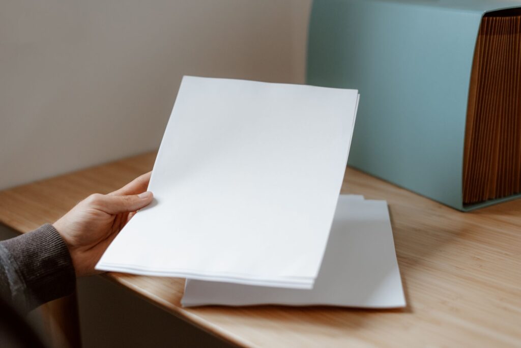 白紙の書類を1枚手に取る手元
