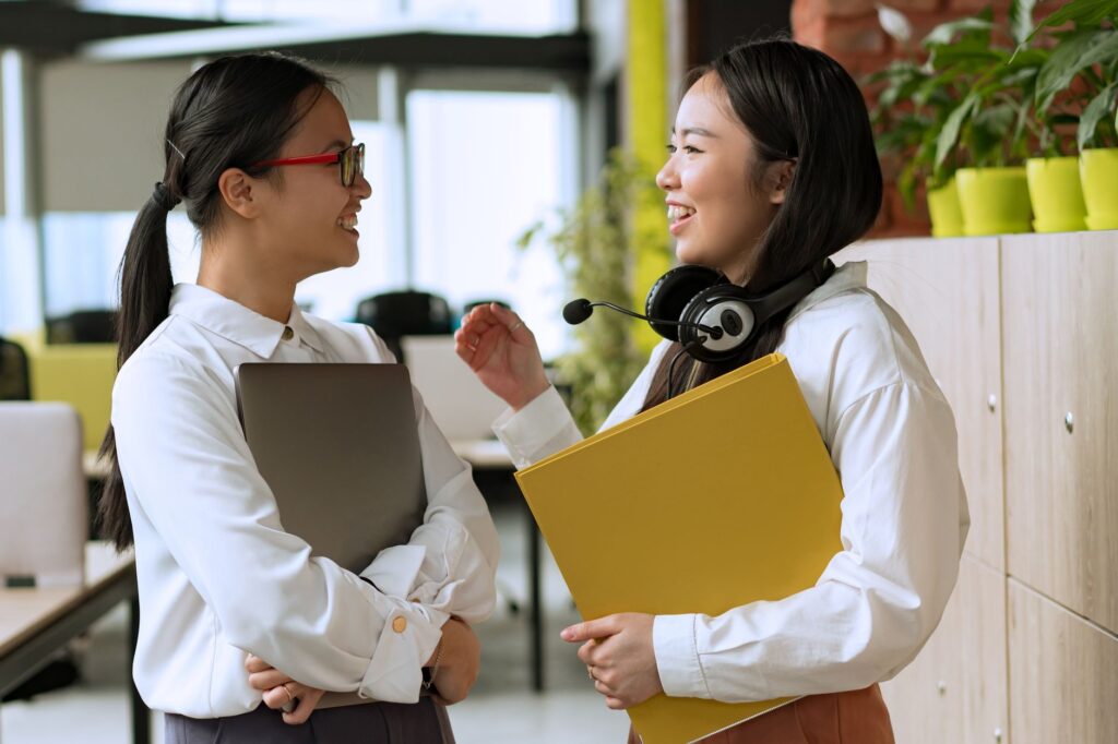 オフィスで向かい合って話す2人の女性