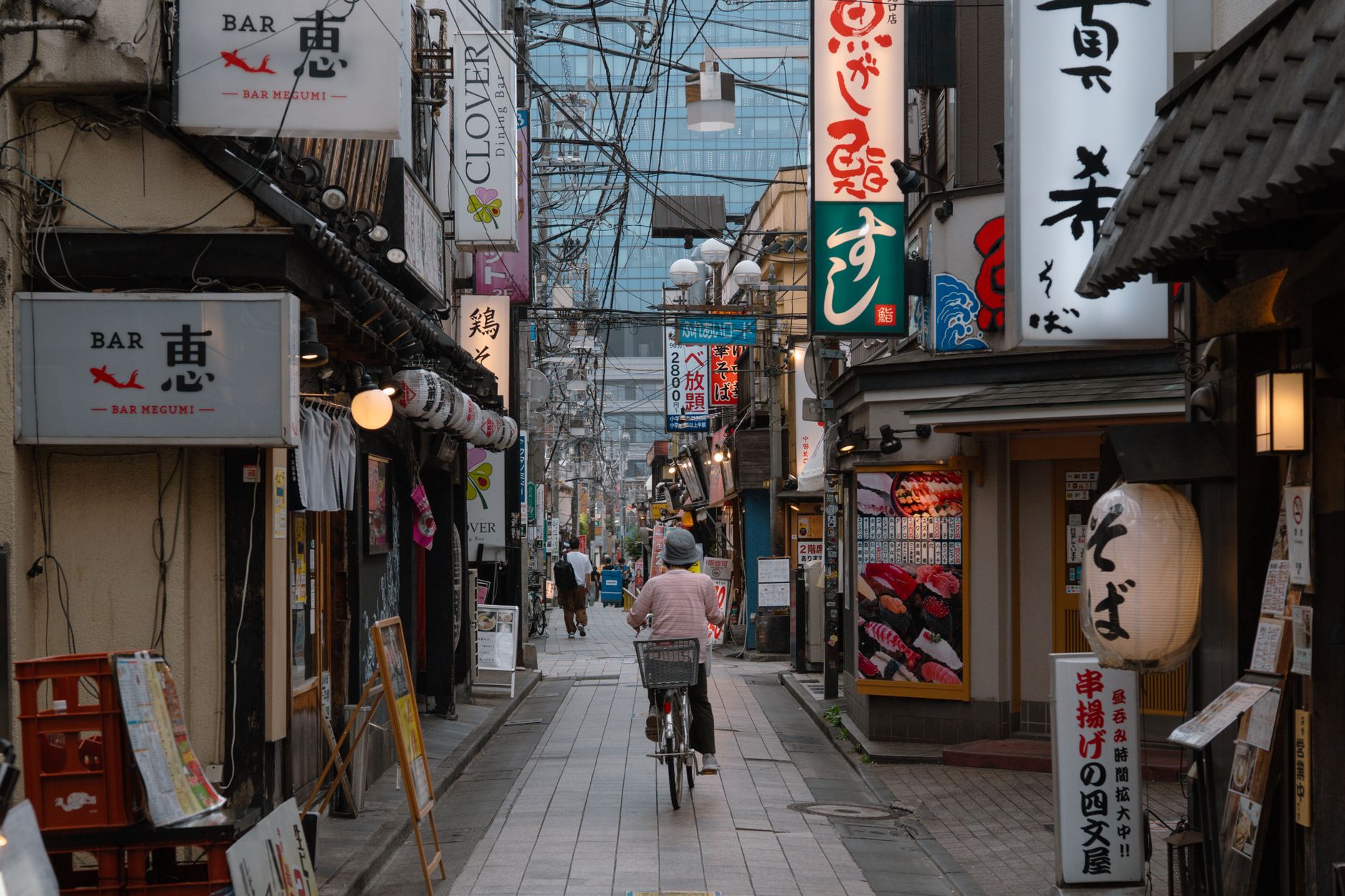 A narrow Tokyo residential street with a cyclist and no centre line
