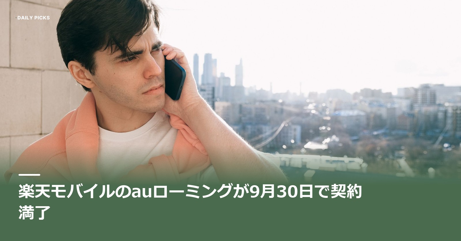 屋外でスマートフォンを耳に当て、通話しながら遠くを見ている人と背景の街並み