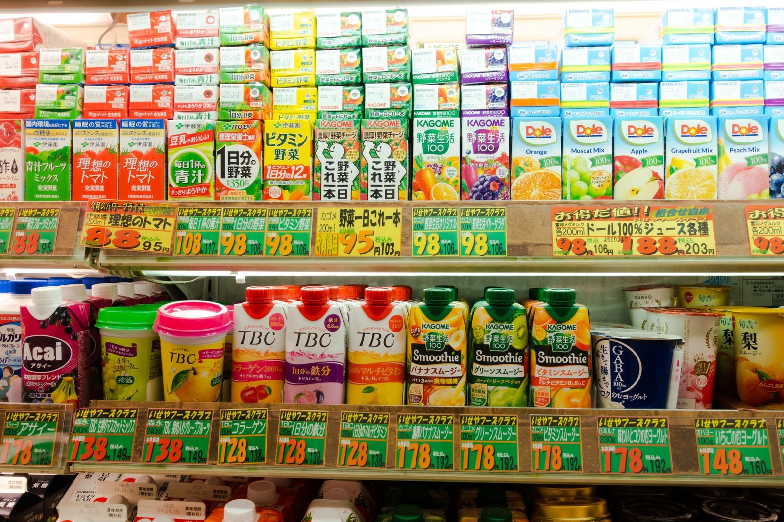 日本のスーパーの飲料売り場の棚。値札に本体価格と税込価格が並べて書かれている